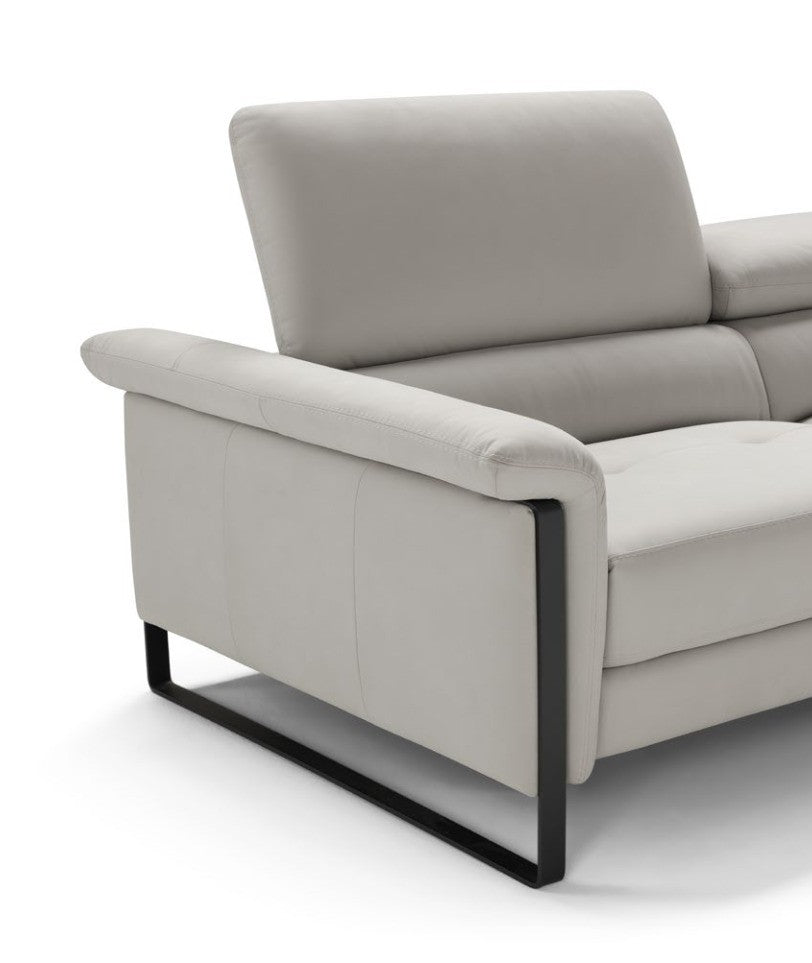 Close-up of the Vitti armrest with the continuous black metal slate leg and raised headrest in light grey leather