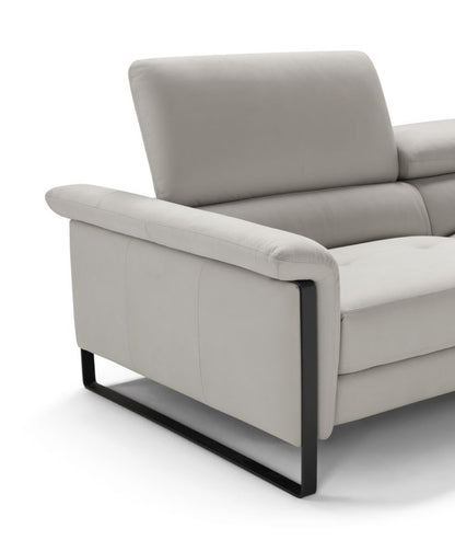 Close-up of the Vitti armrest with the continuous black metal slate leg and raised headrest in light grey leather